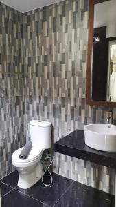 a white toilet sitting in a bathroom next to a sink at Paya Beach Spa & Dive Resort in Tioman Island
