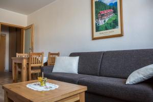 a living room with a couch and a table at Apartmany Belianky in Vysoke Tatry - Tatranska Lomnica.