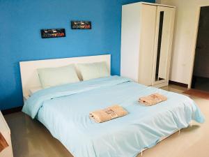 1 dormitorio con 1 cama con 2 toallas en The Rich Home, en Nakhon Ratchasima