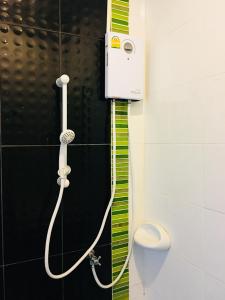 a shower in a bathroom with a phone on the wall at The Rich Home in Nakhon Ratchasima