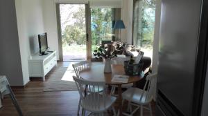 a dining room with a table and chairs and a television at Casa Nueva Playa Areabrava Hio in Hio