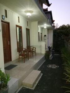 a porch of a house with a table and chairs at Sintya Homestay in Ubud