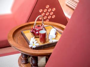 a table with a tea pot and flowers on it at The BARAI by Hyatt in Hua Hin