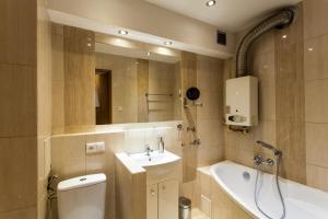La salle de bains est pourvue d'un lavabo, de toilettes et d'une baignoire. dans l'établissement Batory Apartament, à Chorzów