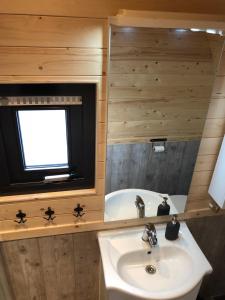 a bathroom with a sink and a tub and a window at Little Lighthouse Texel in De Cocksdorp