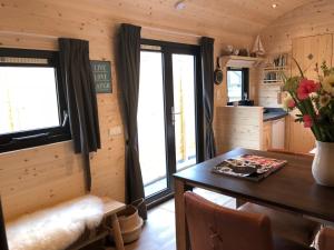 a kitchen and dining room with a table and windows at Little Lighthouse Texel in De Cocksdorp