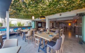 a restaurant with tables and chairs and a large ceiling at Captain Karas Holidays Apartments in Protaras