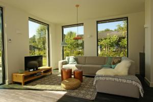 a living room with a couch and a tv at Vakantiehuis Nijmegen in Erlekom