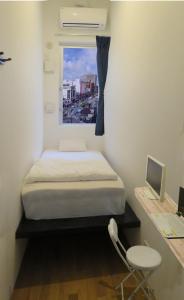 a small bedroom with a bed and a window at Chura Cabin Kokusai-Dori in Naha
