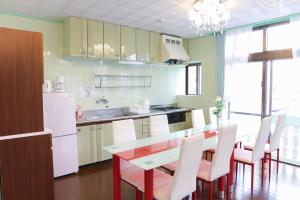 uma cozinha com uma mesa de jantar e electrodomésticos brancos em Ryukyu Tabikan #3F em Ginowan