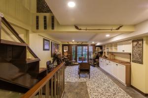 a kitchen with a staircase and a living room at Wannamas Chiangmai Boutique House -SHA Extra Plus in Chiang Mai