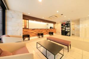 東京にあるスマイルホテル東京綾瀬駅前のソファとテーブルが備わる待合室