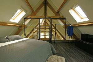 a bedroom with a bed in a room with windows at Vakantiehuis Nijmegen in Erlekom