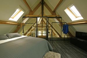 een slaapkamer met een bed in een kamer met ramen bij Vakantiehuis Nijmegen in Erlecom