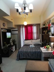Nica's Place Property Management Services at Horizons 101 Condominium في مدينة سيبو: غرفة نوم بسرير كبير وستارة حمراء