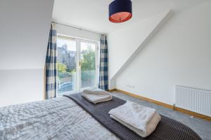 um quarto com uma cama e uma janela em 4 Kinnessburn Cottages em St Andrews