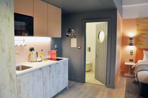a kitchen with a sink and a refrigerator at room2 Southampton Hometel in Southampton