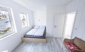 ein Zimmer mit einem Bett und einem Stuhl darin in der Unterkunft Lotsenkoje in Cuxhaven