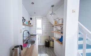 eine kleine Küche mit einem Waschbecken und einer Treppe in der Unterkunft Lotsenkoje in Cuxhaven