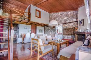 a living room with white chairs and a stone wall at Stonehouse 2 Bedroom Chalet on Olympus Amazing View in Pétra