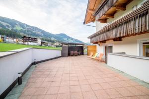 uma varanda de uma casa com uma mesa e cadeiras em Apartment Eberharter em Fügenberg