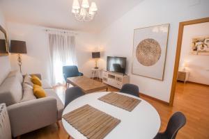 una sala de estar con un sofá y una mesa en Apartamentos Soho Boutique Plaza Mayor Caceres, en Cáceres