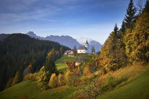 a church on top of a hill in the mountains at Shepherds House "Alpine Dreams" in Solčava