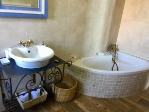a bathroom with a sink and a bath tub at Captain Sunshine Guest House in Jongensfontein +19 photos