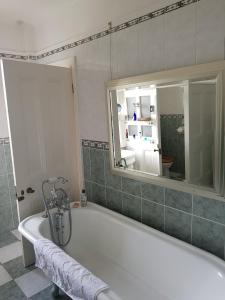 a white bath tub in a bathroom with a mirror at Clift Hill in Carlisle