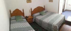 
two beds in a room with two lamps on at Hostal La Casilla in Guitiriz
