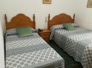 
two beds in a room with two lamps on top of them at Hostal La Casilla in Guitiriz
