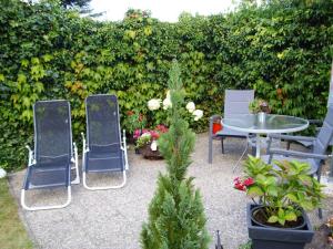 a patio with two chairs and a table and plants at Appartement Muschelkoje in Ostseebad Karlshagen