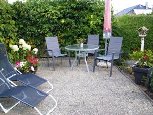 a group of chairs and a table in a garden at Appartement Muschelkoje in Ostseebad Karlshagen