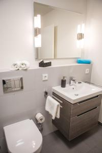 a white bathroom with a toilet and a sink at Fewo an der Kulturbäckerei in Lüneburg