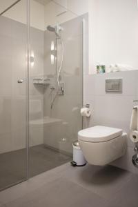 uma casa de banho branca com um WC e um chuveiro em Fewo an der Kulturbäckerei em Lüneburg