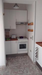 a small kitchen with white cabinets and a stove at Mini appartamento da Cetty in Reggio di Calabria