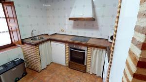 a small kitchen with a sink and a stove at Casa Rural Majada Palentina in Villanueva de Arriba