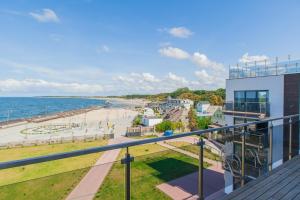a view of the beach from the balcony of a building at Apartamenty Laguna Przy Latarni in Darlowko