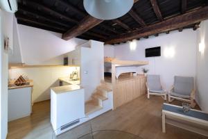 a room with a staircase and a kitchen with two chairs at San Clemente Holiday House in Bracciano