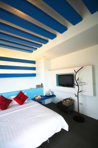 a bedroom with a white bed and a tv at HI One One in Magong