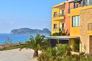 a yellow building next to the ocean with a beach at Pachia Ammos Falasarna in Falasarna