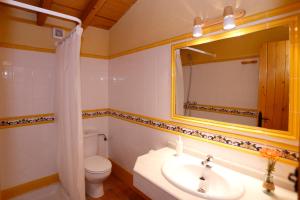 a bathroom with a sink and a toilet and a mirror at Casa Rural Mas de Sant Pau - Turistrat. in Albocácer