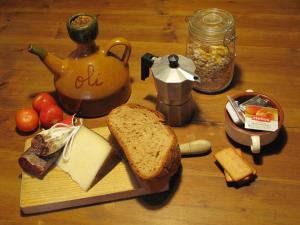 einen Tisch mit einem Schneidebrett mit einem Sandwich und Brot in der Unterkunft L'Esgolfa de ca l'Ortís in Figuerosa