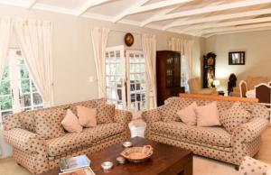 a living room with two couches and a coffee table at Westfield Farm in Balgowan