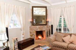 a living room with a couch and a fireplace at Westfield Farm in Balgowan