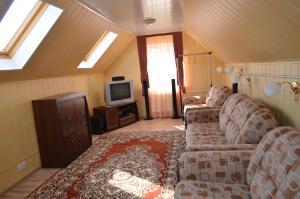 a living room with two couches and a tv at Ziedu pasaule in Krāslava