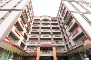 a large white building with red and white trim at Convenient Grand Hotel in Lat Krabang