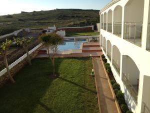 an external view of a building with a yard at Hostal La Palma in Fornells