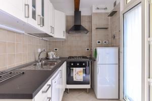 eine Küche mit Spüle und Kühlschrank in der Unterkunft Urbana Colosseo Boutique Apartment in Rom