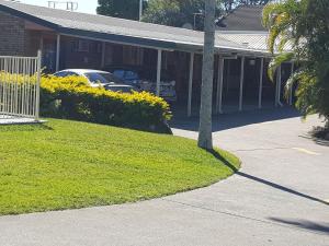 a white car parked in front of a house at Kipparing Village Motel in Redcliffe